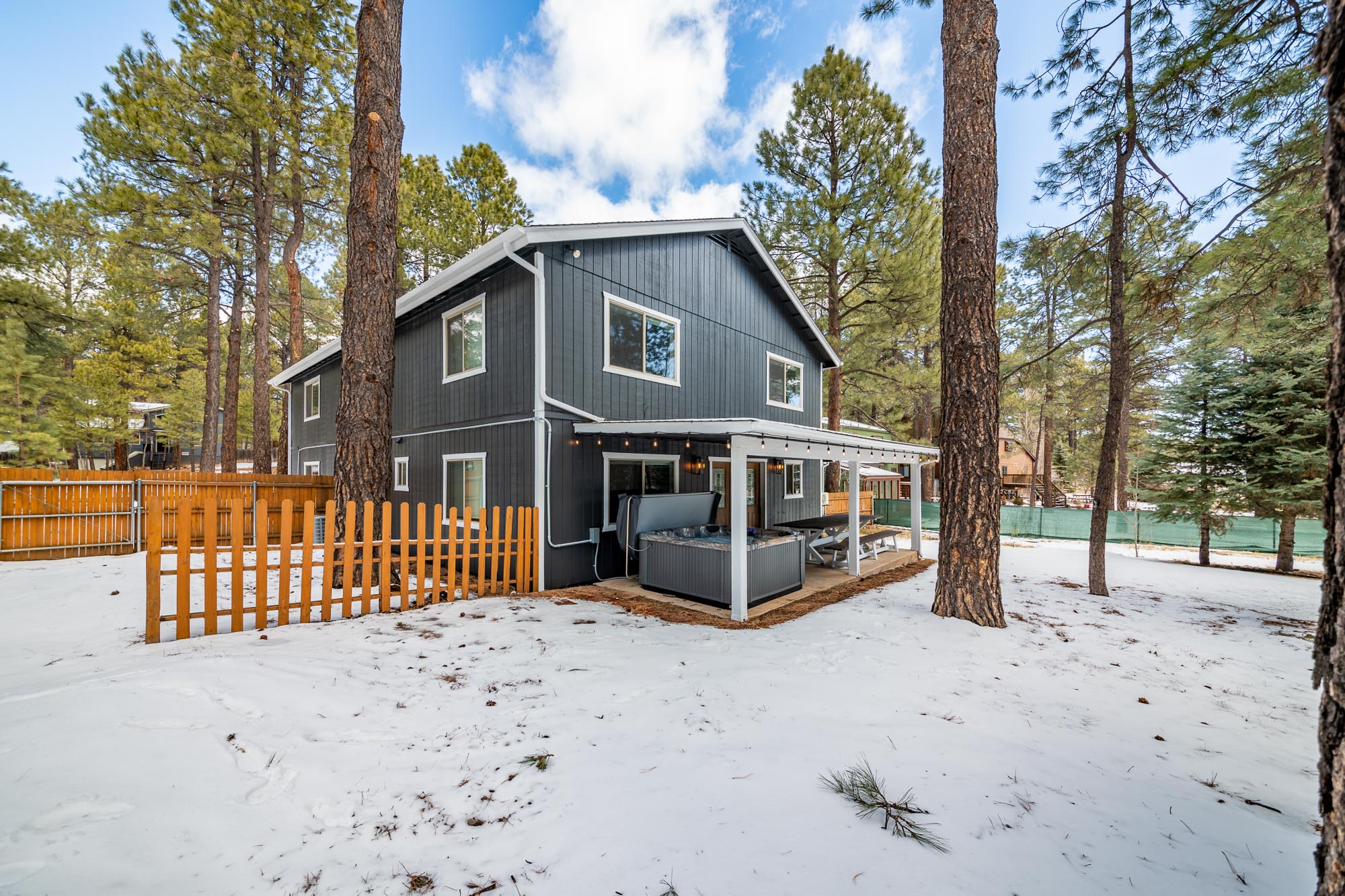 Rear exterior with hot tub and pine trees